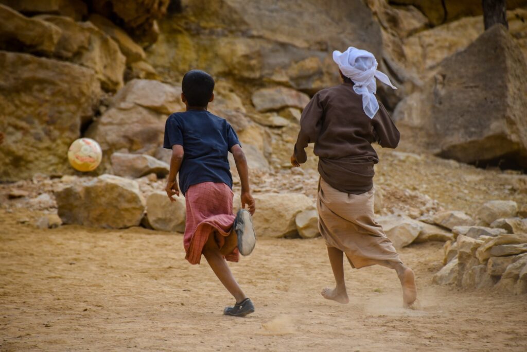 Copii care joacă fotbal la Wadi Bani Khalid